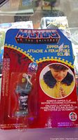 Front of packaging showing Skeletor zipper clip and instructions with image of a child using zipper clip.