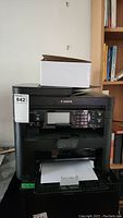 Front view of Canon printer showing model and control panel.