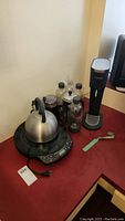 Sodastream sparkling water maker with four bottles, coffee press, tea kettle on countertop