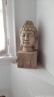 Front view showing Buddha bust sculpture on square base with detailed facial features and head curls.