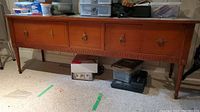 Front view of wood storage table with four drawers and decorative ring pull handles