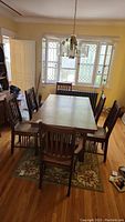 Full view of oak mission dining table with leaves in place and six chairs around it in dining room