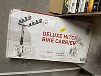 Photo of the boxed Deluxe Hitch Bike Carrier, Model 542RR, for 4 bikes, showing branding and capacity.
