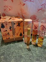 Full lot with perfume bottles, boxed products, bar soap, small containers, and bath pouf arranged on counter.