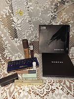 New higher end makeup lot grouped on lace background including Morphe eyeshadow palettes, foundation, lipstick, lip gloss and other makeup items.