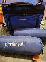 Blue Voyager travel bag with front zippered pocket and black handle straps.