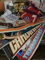 Photo showing sports scarves from San Francisco Giants, Tennessee Volunteers, and other teams with some towels and memorabilia.