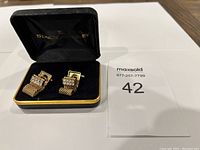 Pair of gold-tone cufflinks with clear rhinestones and chain fringe displayed in black velvet-lined box with gold trim and 'Stacy Adams' branding on inside lid.