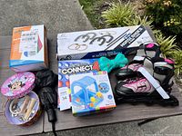 Overview of all items showing horseshoes set, rollerblades, Connect 4 game, throw and catch toy, umbrellas, and Minnie Mouse tin