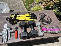 Photo of all workout and sports equipment items on a wooden table outdoors.