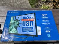 Box front showing Element 32 inch Class LED TV features including HDMI x3, digital ATSC tuner, PC input, and assembled in the USA label.