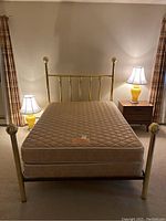 Front view of brass finished bed frame with mattress, showing overall condition and style.