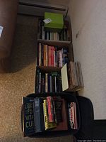 Full view of multiple boxes and containers filled with assorted cookbooks of various conditions and bindings.