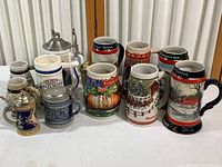 All mugs arranged on table showing six Budweiser mugs plus additional mugs and miniatures