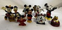Full view of all Disney character figurines including Minnie, Donald, Mickey, Sorcerer Mickey, Pluto, and a Mickey Mouse alarm clock