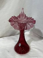 Front view of cranberry glass vase with ruffled tulip top, showing fine dot optic texture and shape.