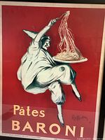 Close-up view of the clown holding plate of pasta on red background with text Pâtes Baroni
