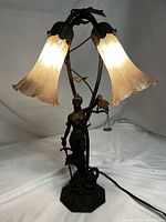 Full lamp showing Lady Justice bronze sculpture base with two lit tulip glass shades.