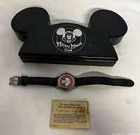 Full lot showing wrist watch, original Mickey Mouse Ear shaped wooden box with Mickey Mouse Club logo, and certificate of authenticity.