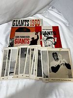 Overview photo of 1960 Giants yearbook, 1962 and 1963 official programs and several black-and-white 5x7 individual player photos spread out.