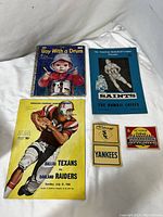 Full view of the collection including the vintage children's book, American Basketball League program, American football souvenir program, and vintage sports stickers.