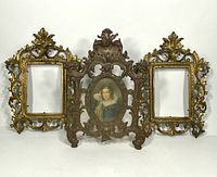 Front view of the three antique Victorian metal photo frames together, showing two gold-tone rectangular ones and one dark metal oval frame with portrait insert.