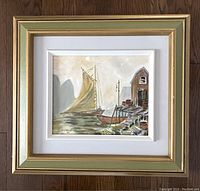 Framed oil painting of a sailboat and dock scene from a distance showing the full frame and artwork.