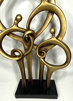 Front view of bronze-tone abstract family figures sculpture, showing interlinked forms and base.