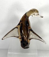 Photo showing front view of amber and clear glass bird figurine on clear stand