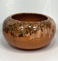 Front angle of round drip glaze planter showing overall shape and exterior finish.