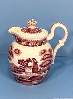 Front and side view of vintage Copeland Spode Tower hot water jug showing detailed tower and bridge scene in red transferware with decorative lid and handle.