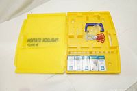 Yellow plastic Brady Padlock Station with compartments and items arranged inside showing station label and layout