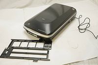 Full view of Epson scanner with two black photo mats/trays for film and photo scanning on white surface.