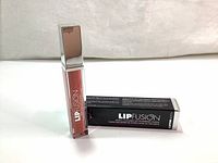 Image showing the lip gloss tube and its box upright on a flat surface.