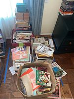 Stacks and boxes filled with various books including cookbooks and gardening books.