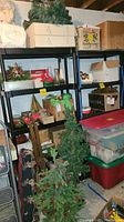 Photo of basement shelving units holding various boxes and decorations. Shelving units black plastic with multiple slatted shelves.