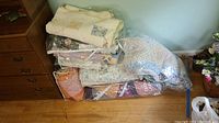 Stack of 5 varied quilts in plastic bags showing colors and textures, highlighting different patterns and sizes.