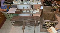 Full view of metal shelving unit and two wooden crates with various items on and around them.