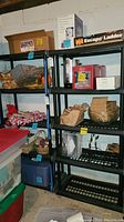 Two black plastic shelving units with various items placed on shelves, demonstrating size and structure. Items on shelves are not included.