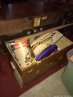 Open wooden toy chest showing vintage toys inside including a Play Box container and other vintage toys.
