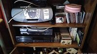 Sony portable stereo, CDs and cassette tapes on two wooden shelves.