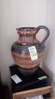 Full view of the ceramic pitcher showing overall shape, color, and texture.