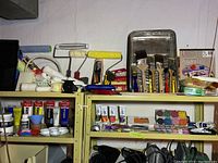 Top shelf showing paint rollers, paint brushes, acrylic tubes, watercolor set and palette trays.
