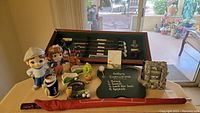 Full view of assortment showing two golf figurines, miniature golf accessories, club display case, football sign, and picture frame