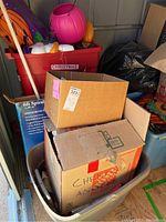 Five large totes and boxes stacked, labeled for Christmas and Halloween decorations in storage shed.