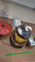 Photo of kitchen appliances including NuWave infrared oven, Presto bread slicer guide box, electric wok with red lid
