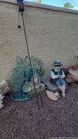 Full lot showing metal lion sculpture, boy statue, small duck statue, tiki torch, stones.