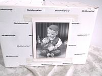 Closed view of the McMemories branded box showing a black and white image of the doll inside.