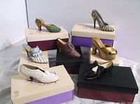 7 women's heeled shoes arranged on boxes showing diverse decorative styles and colors