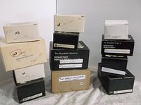 Photo showing stacked boxes of Sebastian Miniatures with labels and catalog numbers such as 'Cleopatra 1962' and 'Sebastian Palace 1979'